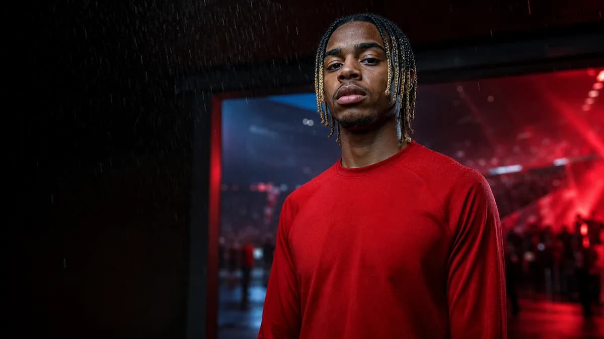 AI editorial interpretation of Bradley Barcola in a plain red training top inside a red-lit stadium tunnel; not an official signing photograph or kit