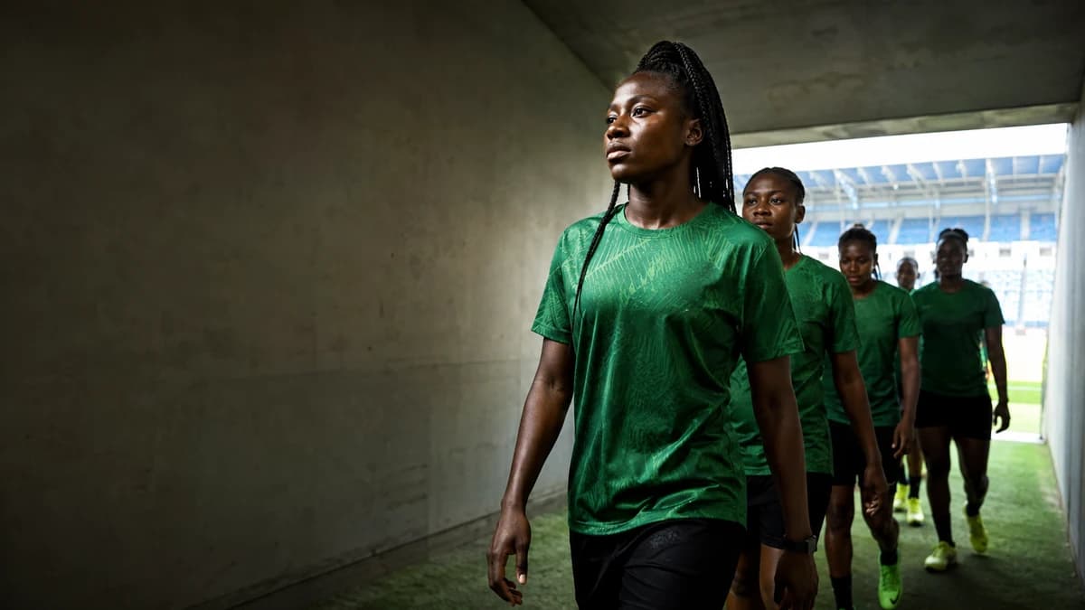 AI editorial scene of anonymous Nigerian under-20 women footballers walking through a stadium tunnel