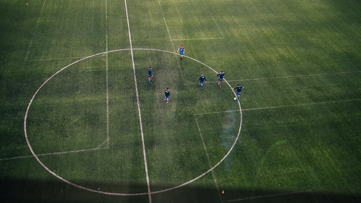 Footballers practising on a grass pitch; a licensed generic editorial photograph, not Group L players.