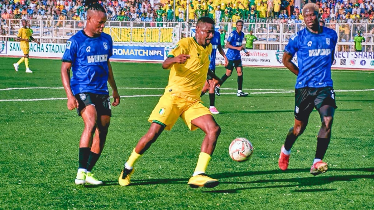 Kano Pillars and Sporting Lagos players compete for the ball in an official NPFL action photograph.